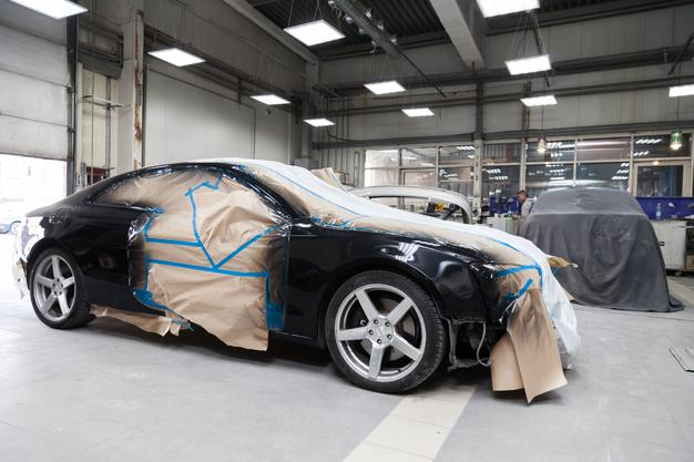 Premium Car Hub technician installing a custom car body kit on a sports car in Dubai